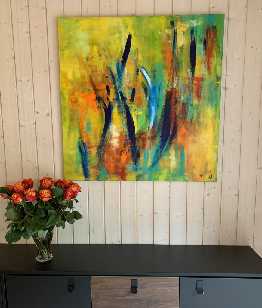 Smuk abstrakt maleri i hjemmet over reolen pynter væggen og matcher blomstene i vasen